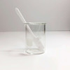 A white rectangular head long handle plastic spatula sitting in a beaker