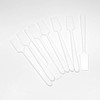 A bunch of white plastic long handle cosmetic spatulas