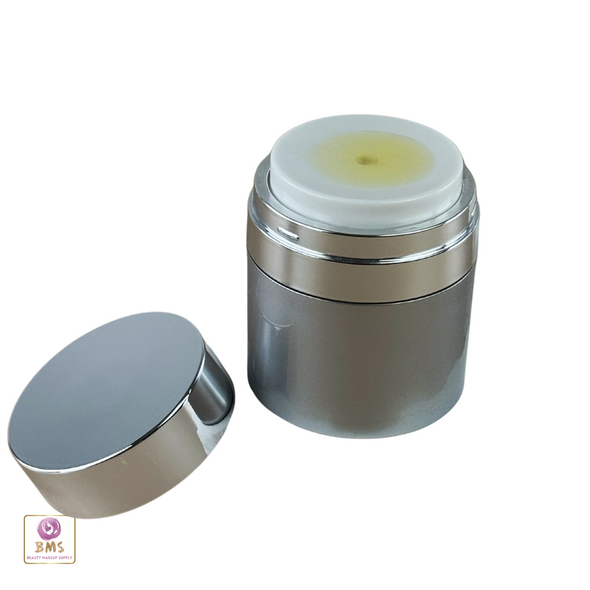A high quality acrylic airless jar with luxurious serum showing on top of the pump and the lid sitting on the side.