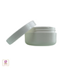 A white beauty container with the lid sitting on the side of the jar that is designed for skincare products.