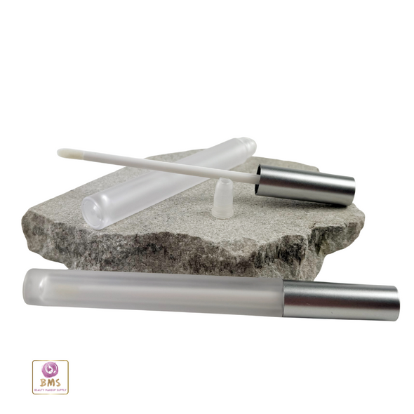 2 slim lip serum tubes one with its components separated - frosted tube, stopper and silver cap attached to a doe foot applicator and the other lip oil tube is assembled.