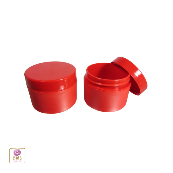 Two red cosmetic jars one with the lid closed and the other one with its cap sitting on the side