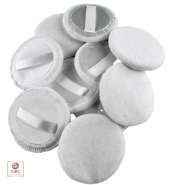 Satin Velour Powder Puff scattered on the table with some just the fluff side facing up and some with the satin strap facing up