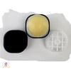 Top view of a black lip balm call with lid on its side and the white lip balm grid